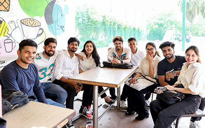 A group of students sitting together in the canteen at IMS Noida, engaging in discussions and enjoying their break.