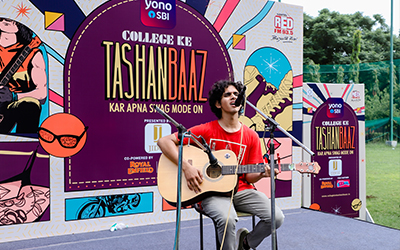 A student performing a song at the Tashanbaaz event at IMS Noida, showcasing their talent on stage.